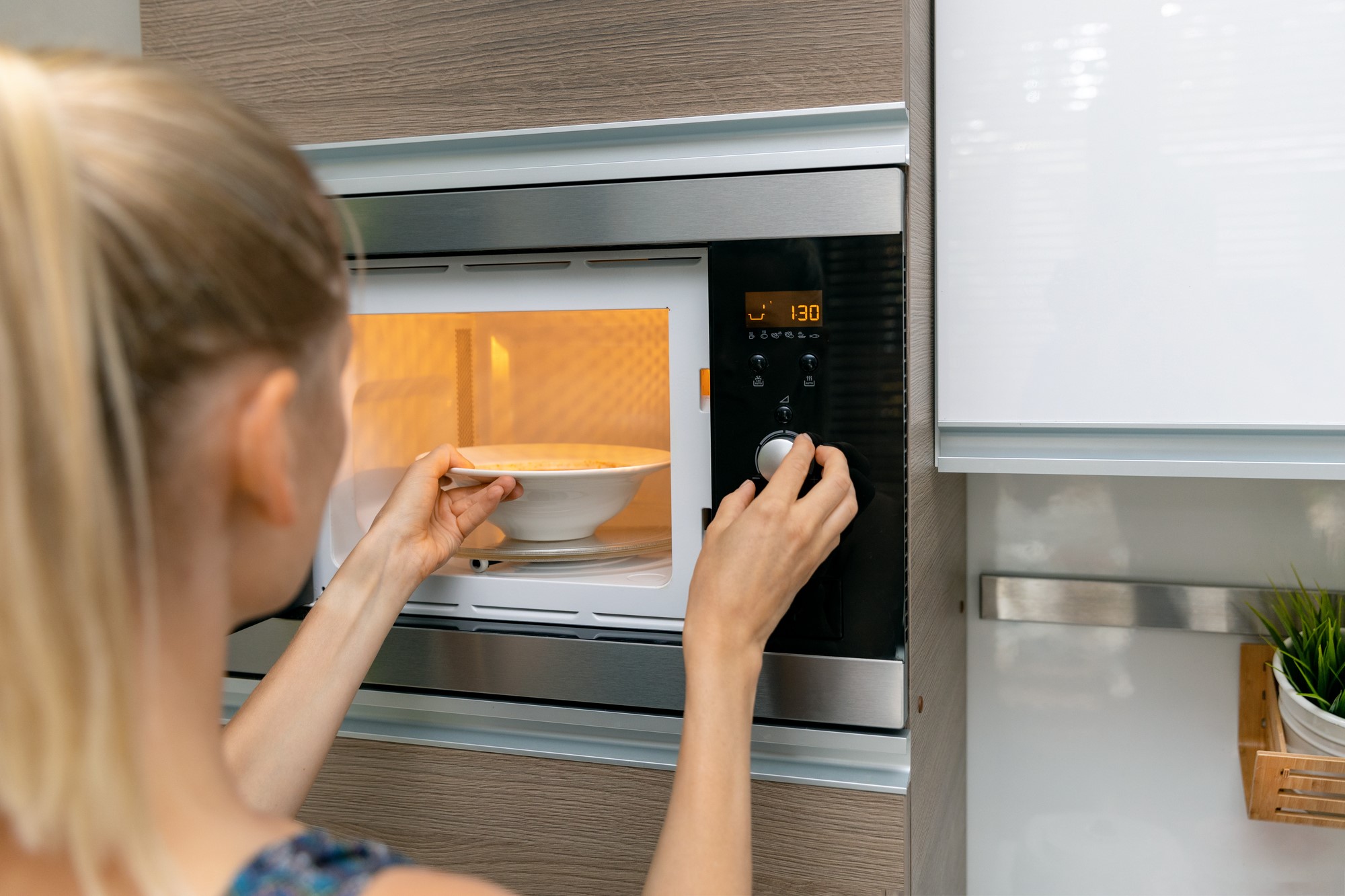 Woman Heating Up Food in Microwave